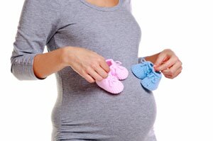  Schwangere Frau mit Baby-Schuhe