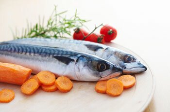  Zwei Makrelen auf einer Platte mit Karotten