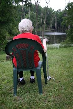  Ältere Dame sitzt an einem See