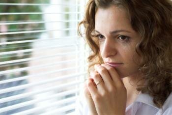  traurige Frau schaut aus dem Fenster