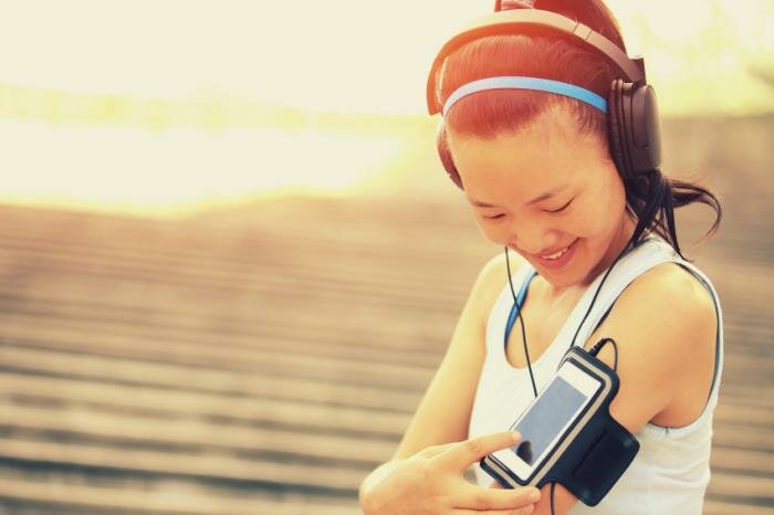  Frau Ausübung und Musik über Smartphone spielen
