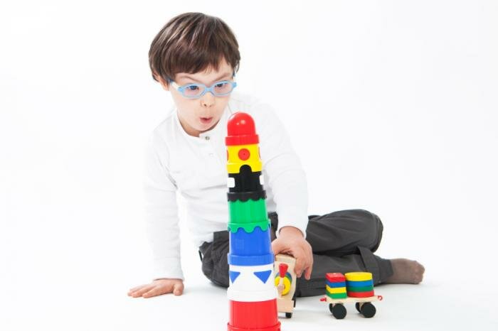  Kind mit Down-Syndrom mit Blöcken spielen