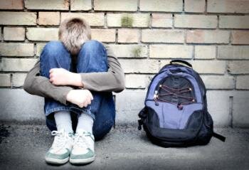  Teenager-Jungen umarmt seine Knie